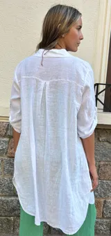 Sobre camisa blanca de lino de corte holgado, con mangas 3/4 y cuello camisero.