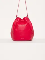 Cartera tipo bucket color rojo, de cuero, con cierre de cordón ajustable y correa larga para colgar del hombro.