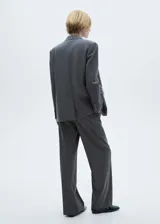 Blazer gris con estampado de raya diplomática, cuello con solapa, cierre de botones en la parte delantera, manga larga con puños abotonados, hombreras y dos bolsillos de solapa en la parte delantera.