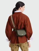 Bandolera Longchamp modelo Épure, color verde oliva, con correa de tela ajustable y cierre con botón a presión.