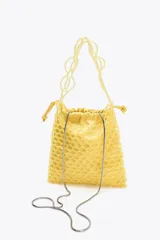 Bolso mini tipo saco con cuerpo de abalorios amarillos, asa de hombro de cuentas y asa bandolera de cadena. Incluye bolsita interior con cierre fruncido.