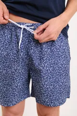 Short de baño azul con estampado de hojas blancas y cordón ajustable en la cintura.