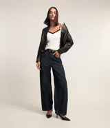 Blusa de breteles finos color blanco con escote en V y superposición contrastante en negro, confeccionada en crepé.
