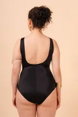 Malla entera de lycra azul marino y blanco, con breteles anchos y escote en V. Tiene un aplique metálico en el centro del escote y un bolsillo interno para colocar una copa removible o prótesis externa.