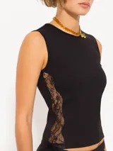 Top negro de punto con calce al cuerpo y cuello redondo. Presenta recortes laterales de encaje y logo JCH bordado en el lateral.