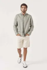 Camisa de lino color blanco, de corte regular, con cuello clásico y mangas largas.