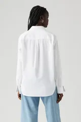 Camisa blanca de corte boyfriend, manga larga y bolsillo en el pecho con logo de la marca.