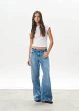 Pantalón de jean celeste de corte wide leg, con diseño de paneles geométricos en las piernas.