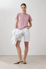 Remera rosa pastel de manga corta con tachas plateadas en los hombros.