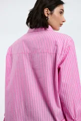 Camisa a rayas verticales rojas y blancas, de corte recto, con cuello clásico, manga larga y bolsillo en el pecho.