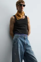 Musculosa blanca de algodón con cuello redondo y sisas amplias, corte ajustado.