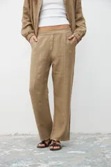 Pantalón caqui de corte recto y tiro alto, con bolsillos laterales y pinzas en la cintura.