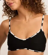 Top de bikini negro con textura acanalada, breteles finos y estampado geométrico en el contorno.