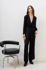 Pantalón palazzo negro con lentejuelas y mostacillas bordadas, tiro medio y cierre lateral invisible.