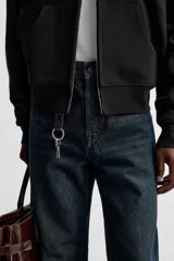 Jeans azul oscuro de corte recto, con largo al tobillo, confeccionados en denim de algodón con efecto lavado. Diseño de cinco bolsillos y cierre frontal con botones.