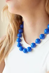 Collar de cuentas esféricas grandes de acrílico blanco, ensartadas en un cordón claro.