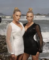 Vestido corto blanco con escote en V, mangas largas abullonadas de tul semitransparente con lentejuelas y cierre invisible en la espalda.