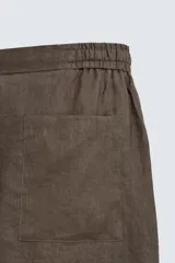 Bermuda negra de lino con calce relajado. Presenta cintura elástica ajustable con cordón, bolsillos frontales y un bolsillo trasero de plastrón.