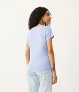 Blusa blanca de algodón con cuello en V, manga corta y bolsillo frontal.