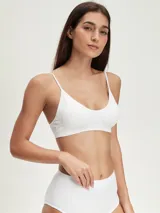 Top deportivo blanco sin costuras, con breteles finos y escote redondo.