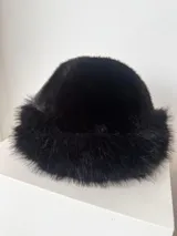 Gorro de piel sintética color negro, con forma redondeada y ala corta.