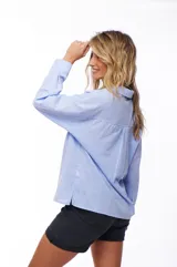 Camisa celeste de manga larga con cuello clásico y bolsillo en el pecho.