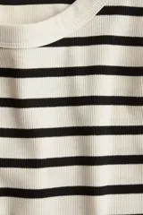 Remera ajustada de punto acanalado a rayas horizontales negras y crudas, con cuello redondo y bajo recto.