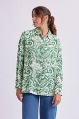 Camisa de manga larga con cuello clásico y estampado floral en tonos verde y blanco.