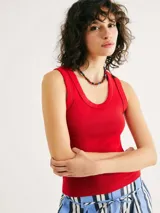 Musculosa negra de tela acanalada, con escote redondo pronunciado (cuello U) y corte ajustado al cuerpo.