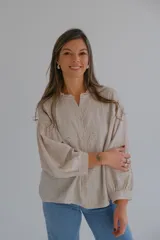 Camisa beige de lino con bordado de flores, cuello mao con volados y mangas largas abullonadas.