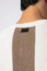 Remera de hombre tejida en algodón color crudo, con textura piqué y rayas verticales marrones y negras.