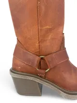 Bota de caña alta color negro, estilo biker, confeccionada en cuero engrasado con detalle de estribo con hebilla.
