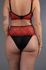 Bombacha de tiro alto color rojo con encaje floral y elástico negro en la cintura.