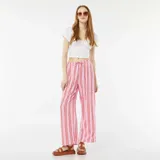Pantalón ancho de punto gofrado color rosa con rayas verticales rojas y cintura con cordón ajustable.