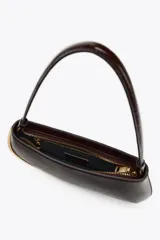 Bolso de hombro marrón oscuro con detalle metálico dorado en un lateral. Tiene un bolsillo interior con cremallera, asa de hombro y cierre con cremallera.