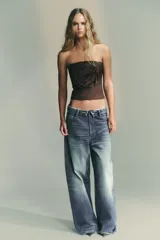 Top bandeau marrón de escote recto y hombros descubiertos, con detalle de flor en relieve en el delantero y cierre lateral con cremallera oculta.