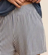 Conjunto de pijama short doll, compuesto por una remera azul con estampado de la frase "Chase The Sun" y un short a rayas verticales blancas y azules con cintura elástica.