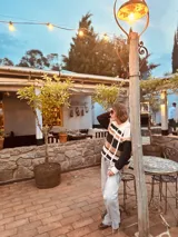 Sweater de punto con diseño a rayas horizontales en tonos blanco, negro, marrón y rosa.