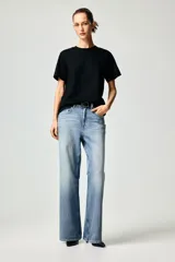 Remera negra de corte recto en punto suave de algodón con cuello redondo ribeteado y hombros ligeramente caídos.