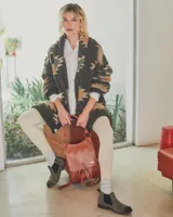 Botines Chelsea de cuero negro con elástico lateral y suela marrón.