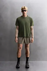 Camiseta deportiva verde militar confeccionada en tejido estructurado, ligero y elástico. Tiene cuello redondo, manga corta y bajo con aberturas laterales. Incluye logo estampado en el bajo.