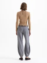 Pantalón Victoria gris confeccionado en lanilla con fit amplio y cómodo. Cuenta con bolsillos ocultos en el delantero y bolsillos ojal en la parte trasera. Presenta presillas y ajuste en los tobillos mediante elástico, que aporta una silueta relajada y caída.