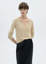 Jersey de punto fino color beige con cuello en V y mangas largas.