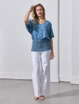Blusa celeste con estampado floral, escote en V y ruedo smock.