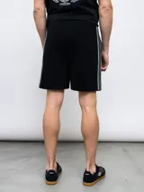 Bermuda deportiva azul marino de piqué con cintura elástica ajustable con cordón, bolsillos laterales y logo Umbro bordado en blanco.