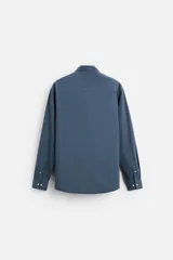 Camisa de vestir azul petróleo, corte regular, confeccionada en mezcla de algodón. Cuenta con cuello solapa, mangas largas con puños abotonados y cierre frontal con botones.