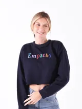 Buzo corto azul marino con mangas largas y la palabra 'Empathy' estampada en letras de colores en el frente.