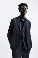 Pantalón negro de corte cropped, con cintura elástica ajustable con cordón, bolsillos laterales y traseros de vivo. El bajo tiene terminación con vuelta.