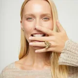 Anillo de aleación de metales bañado en oro 18k con dije principal en forma de corazón tridimensional y liso.