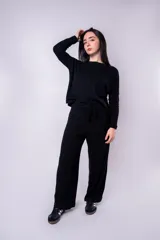 Pantalón negro de tejido de punto acanalado, corte palazzo y cintura alta con lazo ajustable.